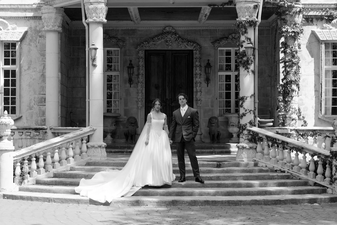 Bride and groom on the steps of the château at dusk
