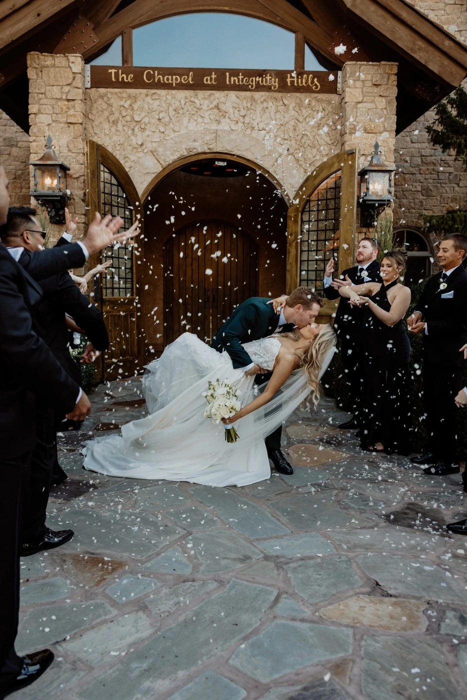 Confetti exit as Hunter dips Nataly outside the stone chapel