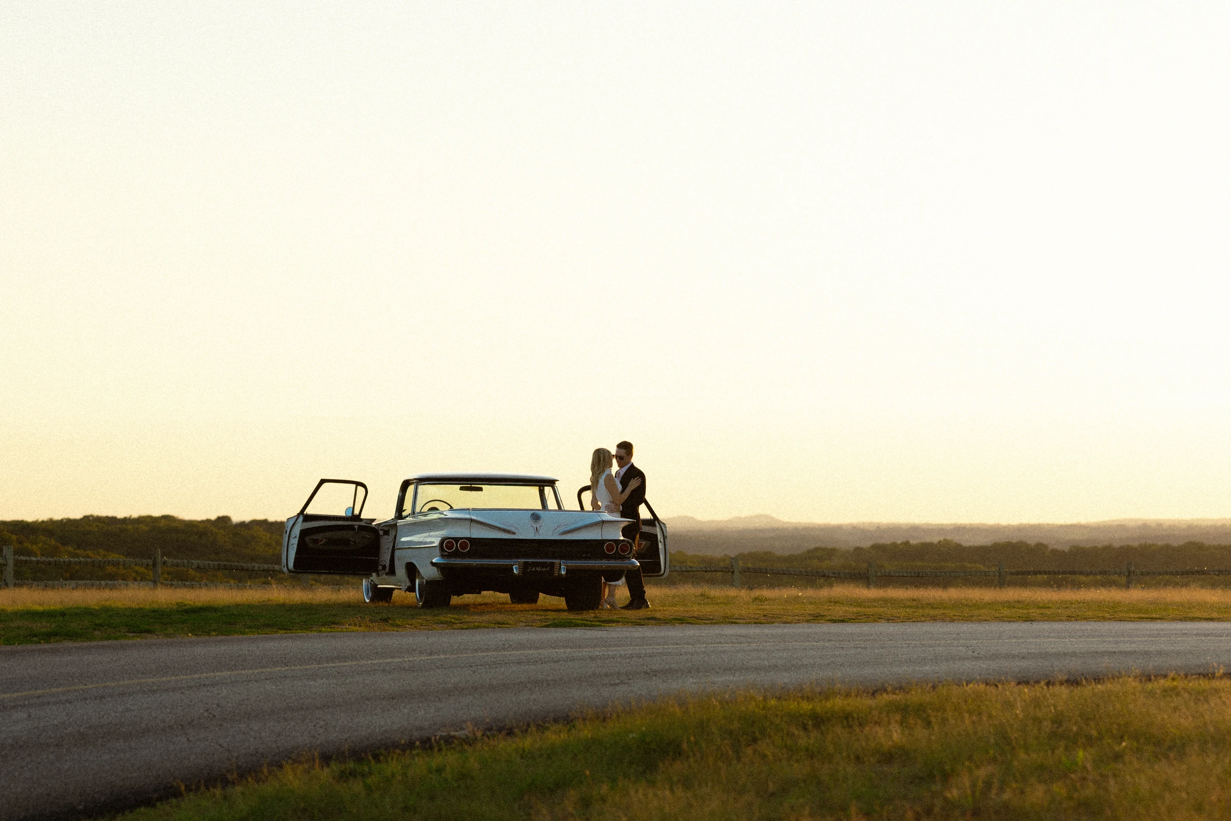 Hunter and Nataly's vintage getaway car at golden hour above the hills at Top of the Rock