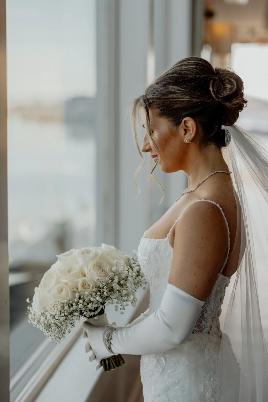 Meghan by the window with her bouquet before the ceremony at The Piermont