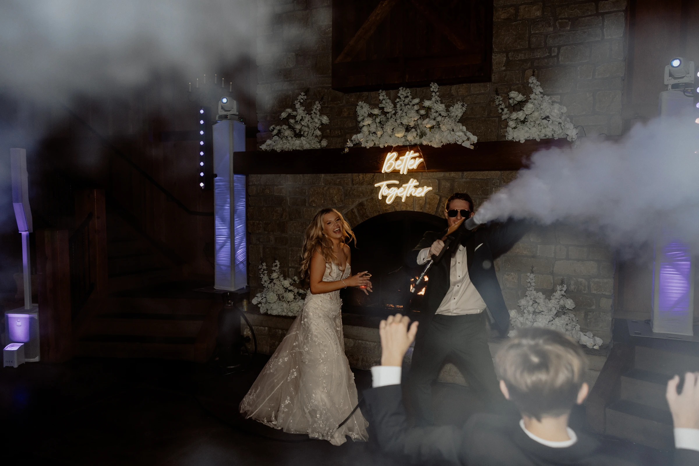 Hunter firing a smoke cannon as Nataly laughs beneath the Better Together neon sign